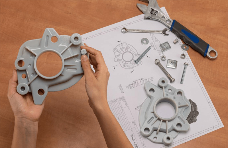Tekniker inspekterar 3D-printade komponenter från Stratasys – funktionella prototyper jämförs med ritning och monteringsdetaljer