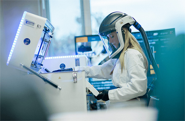 Tekniker arbetar vid Xact Metal 3D-skrivare för metall i industriell miljö